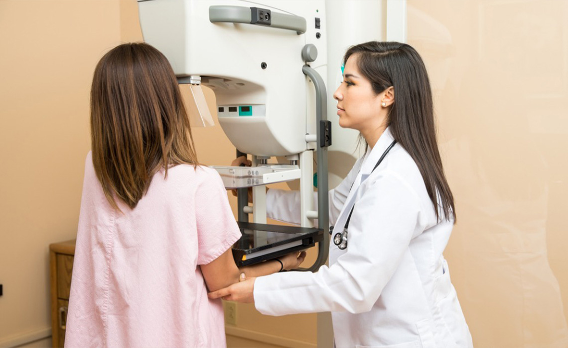 A female patient receiving mammogram.